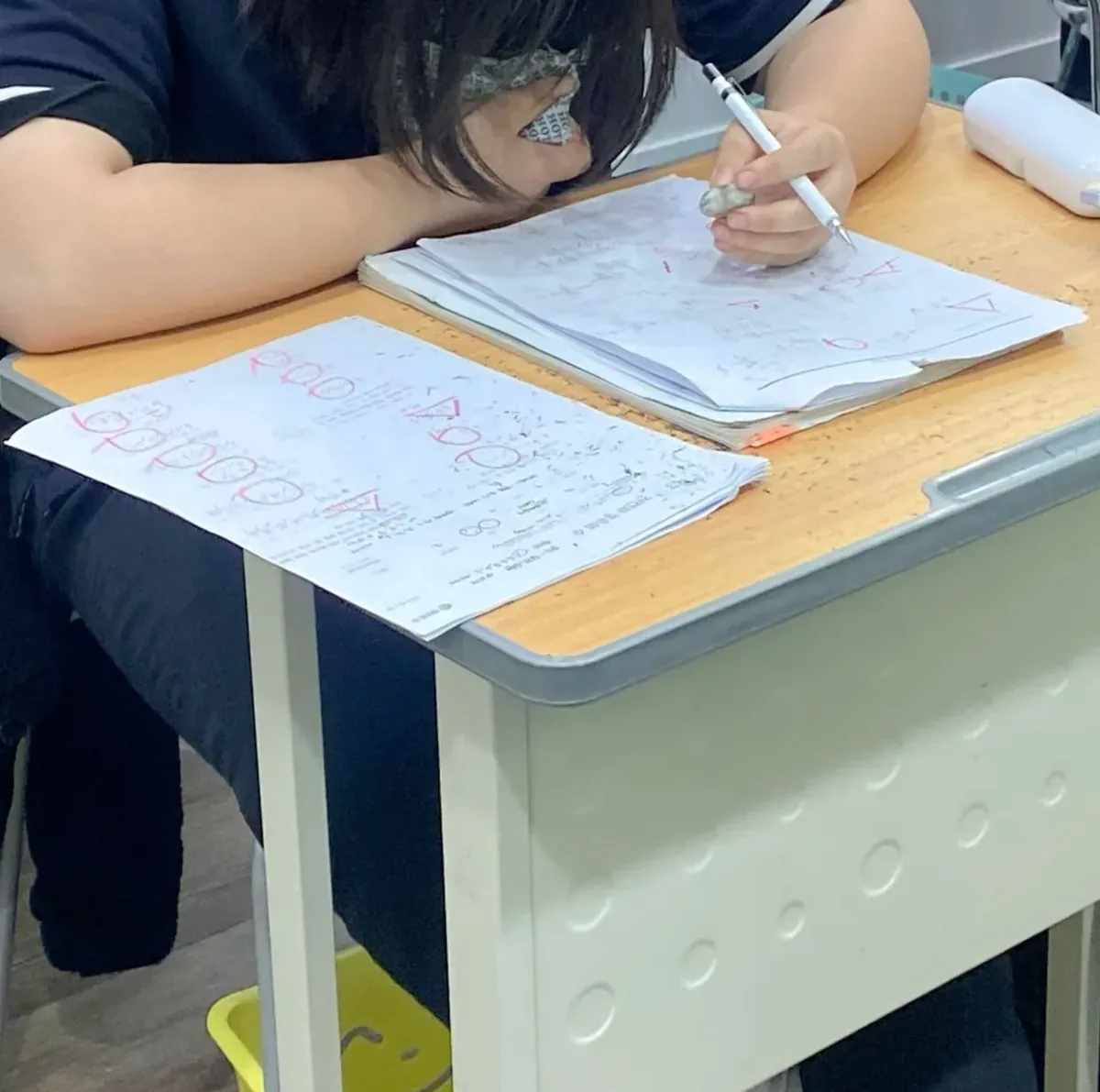 오답을 정리하며 공부하는 학생의 손과 교재